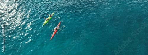 Aerial drone ultra wide photo of athletes competing with rowing in sport canoe in deep emerald paradise exotic island bay photo