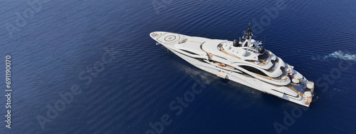 Aerial drone ultra wide top down panoramic photo with copy space of luxury yacht with wooden deck anchored in deep blue island bay with crystal clear sea © aerial-drone