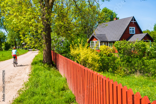 Fototapeta Naklejka Na Ścianę i Meble -  Cyclist riding bike on gravel road near Wigry lake in Wigry National Park, Podlasie, Poland