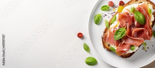 Breakfast or brunch Open sandwich with prosciutto or jamon on white plate Mediterranean appetizer Top view overhead. Copy space image. Place for adding text