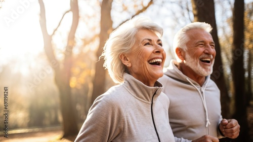 An energetic senior couple, brimming with joy, jogs together in the park. Their smiles radiate warmth and vitality as they enjoy their active lifestyle. photo