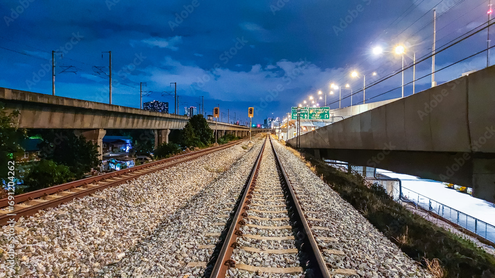 Obraz premium railway in the distance at night nearby highway