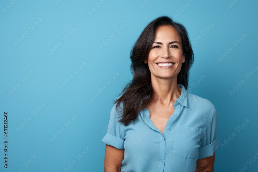 Portrait of smiling businesswoman in blue shirt on blue background. Portrait of smiling businesswoman in blue shirt on blue background.