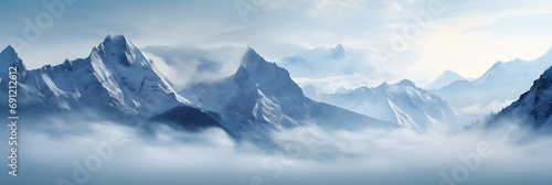 a panoramic view of snowy mountains with snow covered peaks covered with fog and snow in winters © DailyLifeImages