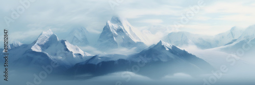 a panoramic view of snowy mountains with snow covered peaks covered with fog and snow in winters