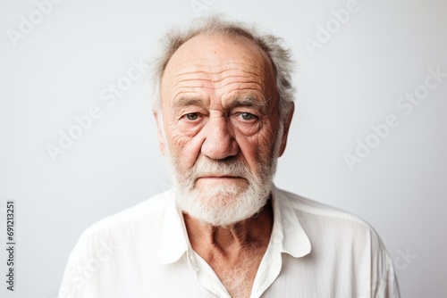 Portrait of an old man with grey hair and beard looking at camera © Inigo