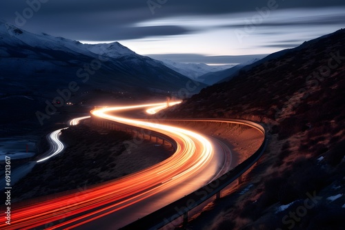 a highway road with cars moving fast with motion blur between snowy mountains