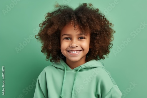 smiling african american little girl in green hoodie on green background