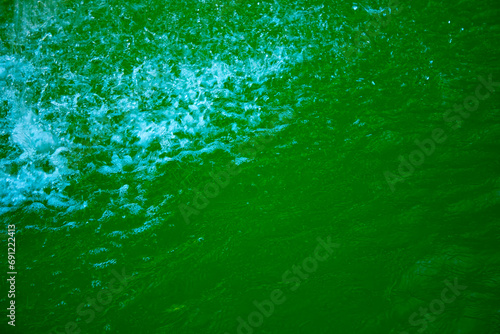 Transparent dark green clear water surface texture with ripples, splashes