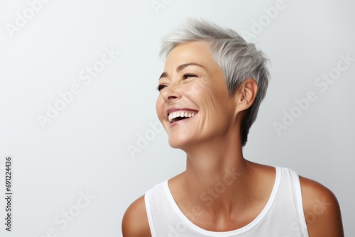 portrait of happy smiling middle aged woman with grey hair over grey background