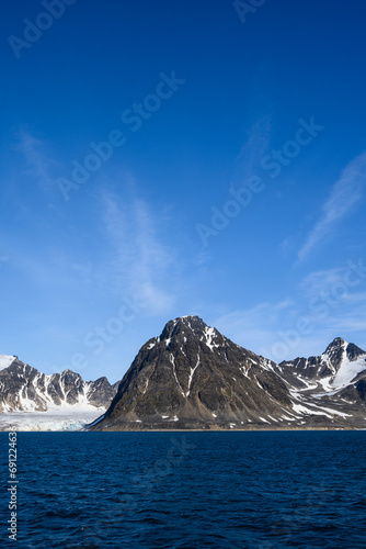 Dramatic clouds in the sky above the mountain peaks in Smeerenburg Fjord, Svalbard, in the summer arctic  © knelson20