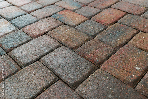 Close up showing driveway area sealant to protect the bricks paving. Sealcoating background for new home construction.	