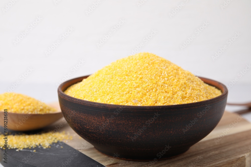 Raw cornmeal in bowl on table, closeup Raw cornmeal in bowl on table, closeup