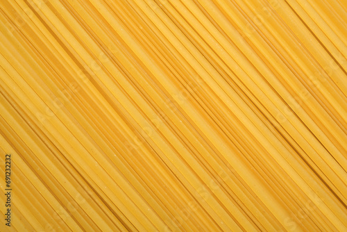 Raw spaghetti pasta as background, top view