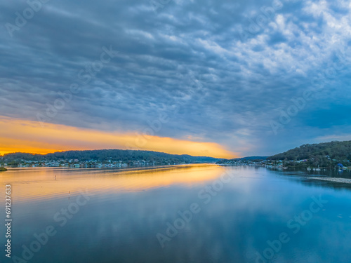 Heavy cloud covered sunrise over the bay with colour and reflections