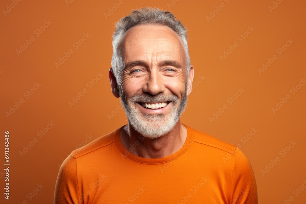 Portrait of a smiling senior man in orange t-shirt on orange background. Portrait of a smiling senior man in orange t-shirt on orange background.