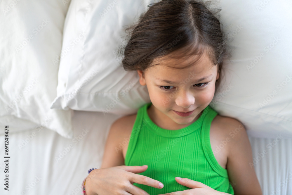 Portrait happy cute girl smiling face looking at camara and think in bed, kid, child, young adorable, student, elementary school and education concept Portrait happy cute girl smiling face looking at camara and think in bed, kid, child, young adorable, student, elementary school and education concept