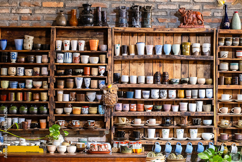 Small store with many pottery ceramic standing on shelves.