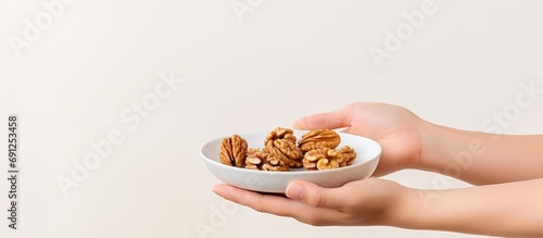 Woman's hand with walnuts while snacking healthily and working. photo
