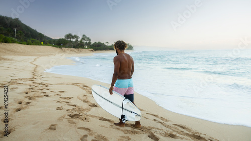Man surfer on the beach before surfing