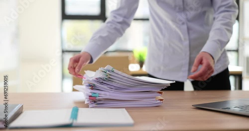 Business woman holding stacks of documents overloaded with paper files photo