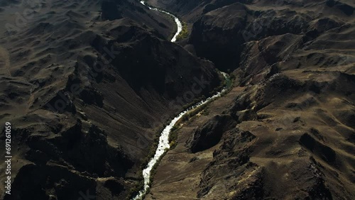 Aerial view tilting over a river in the highlands of Kazakhstan, sunny day photo