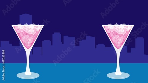 A cocktail in a glass with the night view in the background photo