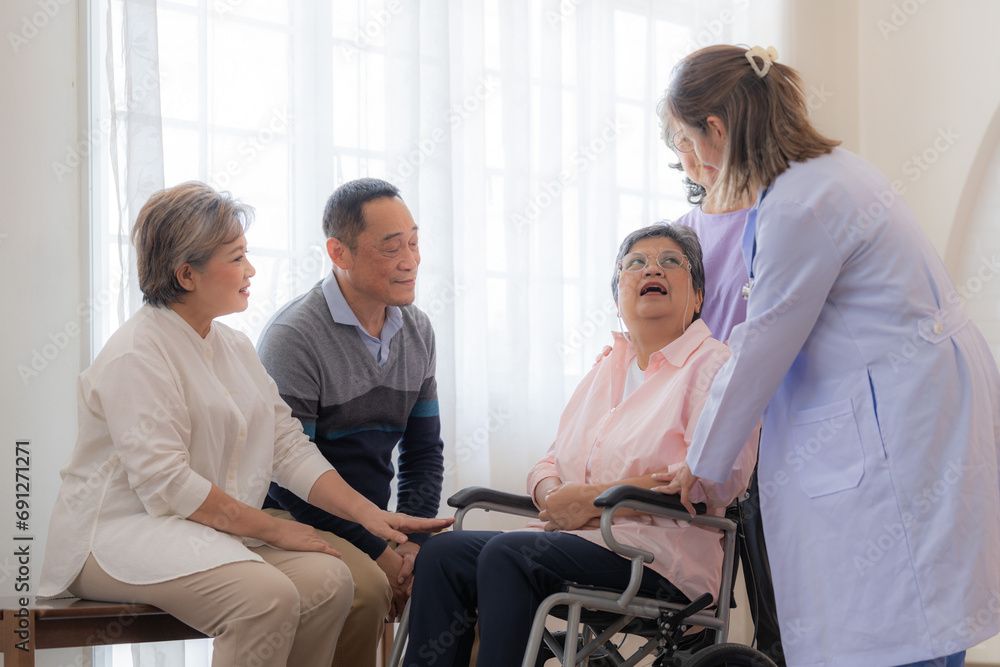 Asian young nurse support couple senior older woman in a wheelchair. elderly mature and a group of senior friends living in the hospital. socializing of retired people. Asian young nurse support couple senior older woman in a wheelchair. elderly mature and a group of senior friends living in the hospital. socializing of retired people.