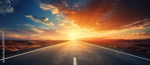 Fotografija Traveling on a vast deserted highway, heading towards the extraordinary sunlight