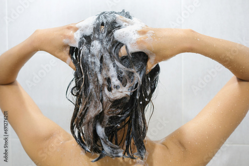 Beautiful woman's hand She was washing her hair and nourishing her scalp. Shampoo and conditioner photo