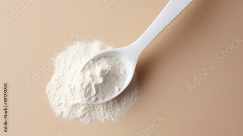 Spoon with collagen or protein powder on pastel background. Natural supplement for beauty and health of skin, bones, joints and intestines. Plant or fish based. Flatley, top view. photo