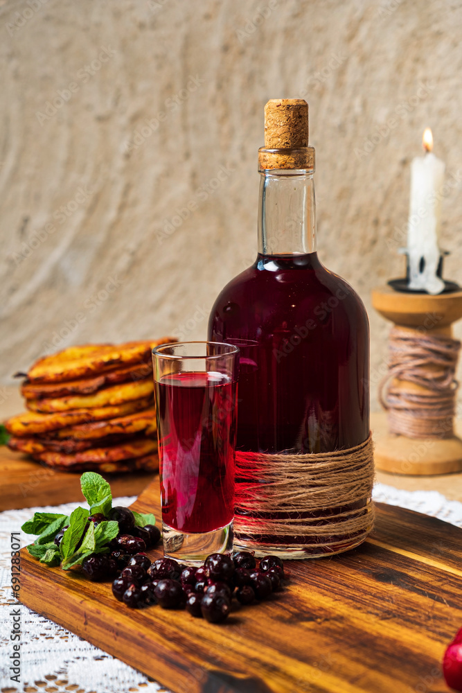 Naklejka premium berry tincture on the wooden board