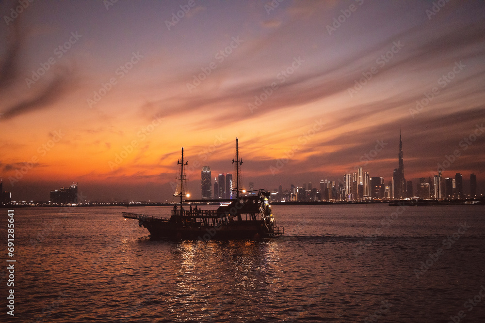Amazing shot of boat  and showing dubai sky line at back side sun set time