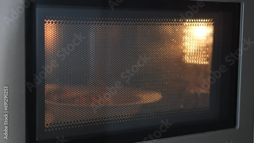  bowl with vegetables in microwave oven, closeup.