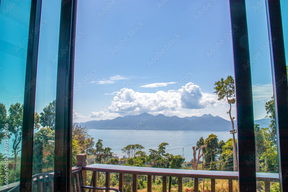Fototapeta premium Islands, clouds floating high above the lush green treetops. beautiful landscape Take photos through rooms inside the building.
