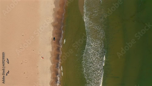 Aerial view of ocean waves coming to the beach at sunny day photo