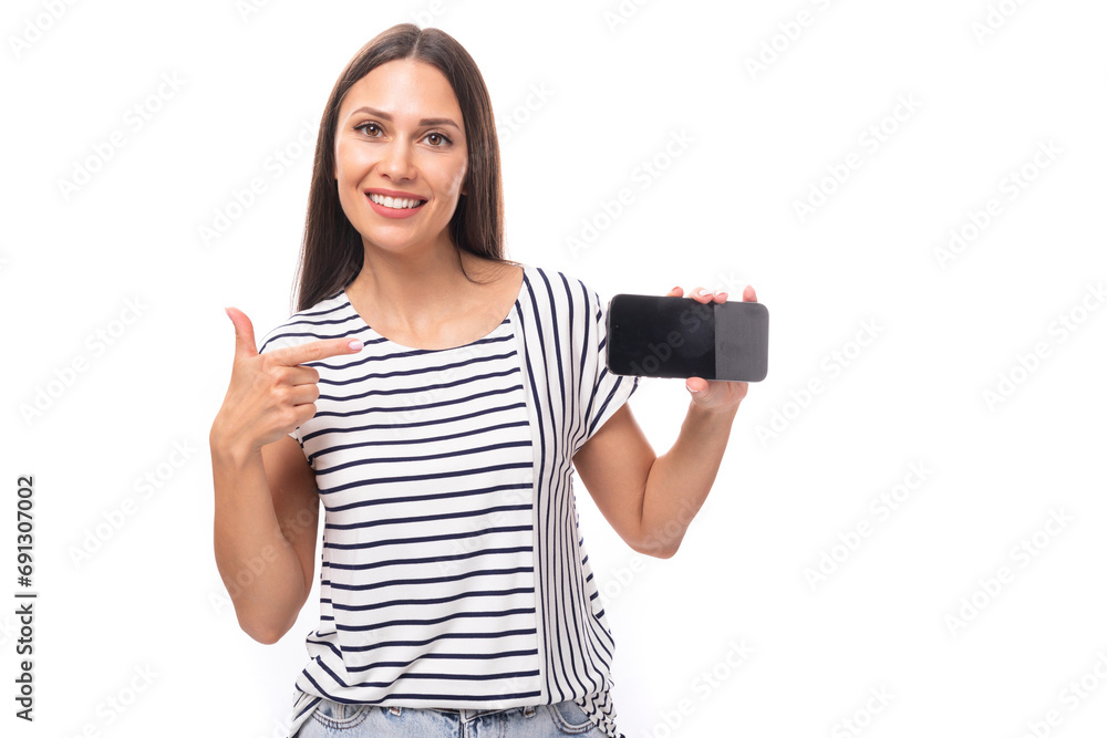 30 year old pretty brunette model woman with long straight hair dressed in a striped t-shirt shows a mobile phone horizontally 30 year old pretty brunette model woman with long straight hair dressed in a striped t-shirt shows a mobile phone horizontally