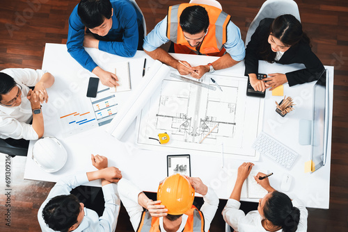 Top view banner of diverse group of civil engineer and client working together on architectural project, reviewing construction plan and building blueprint at meeting table. Prudent photo