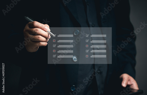 Questionnaire concept Online document management. DMS. Businessman checks list at virtual screen. Answering questionnaires about satisfaction Work via mobile phone or laptop. Satisfaction quality.