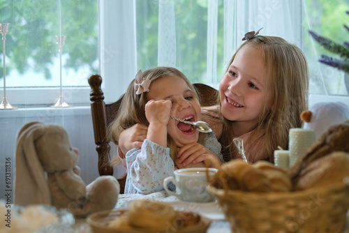 Rustic afternoon: Little siblings bond over an English tea session in a cozy village home