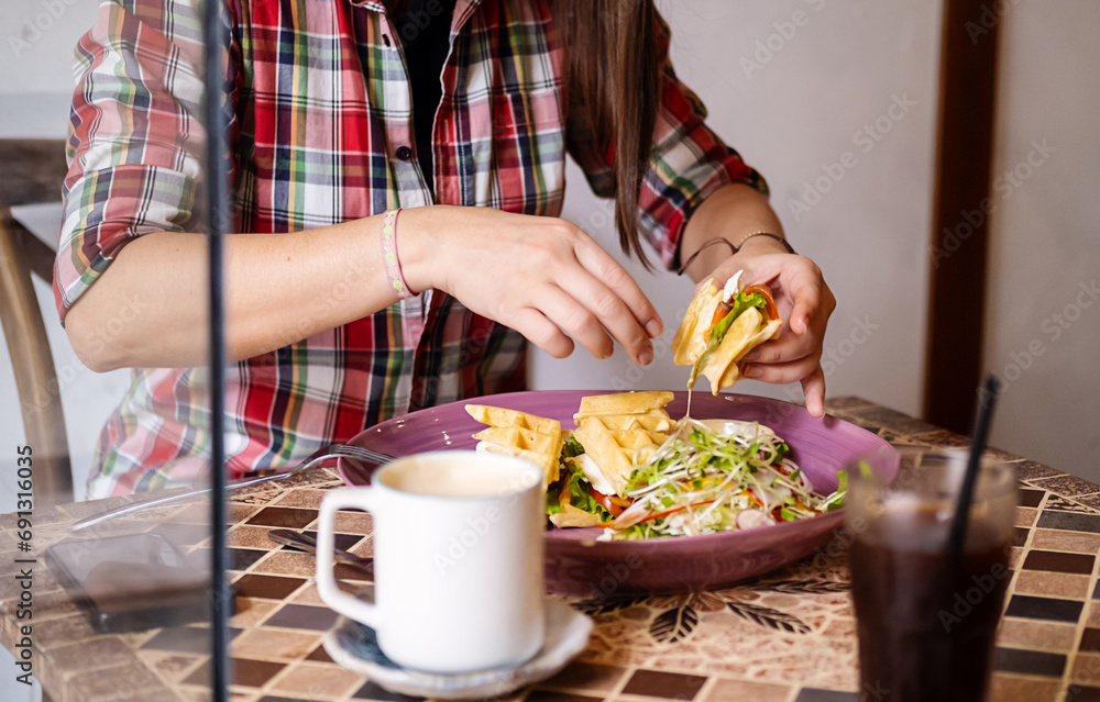 Caucasian woman in casual clothes having lunch in cafe.