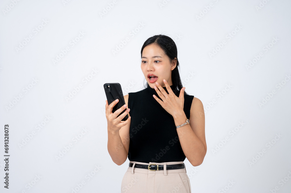 A shocked woman is looking at her smartphone screen with a stunning face, isolated white background. A shocked woman is looking at her smartphone screen with a stunning face, isolated white background.