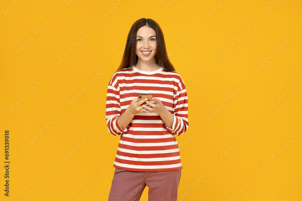 A girl with a phone on a yellow background. A girl with a phone on a yellow background.