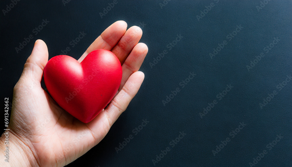 Hand holding a heart symbol, copy space on a side Hand holding a heart symbol, copy space on a side