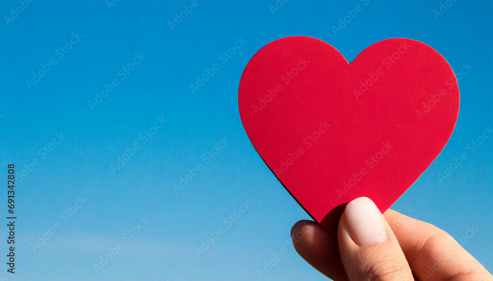 Hand holding a heart symbol, copy space on a side Hand holding a heart symbol, copy space on a side