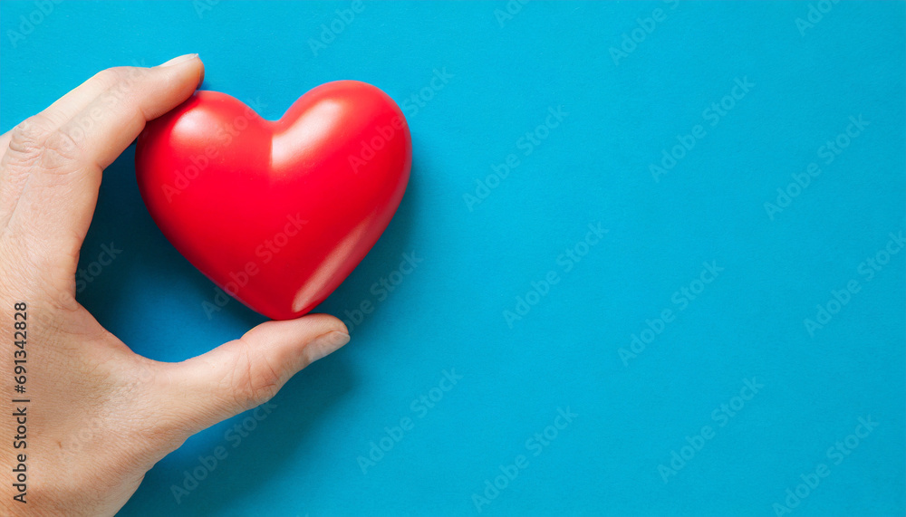 Hand holding a heart symbol, copy space on a side Hand holding a heart symbol, copy space on a side