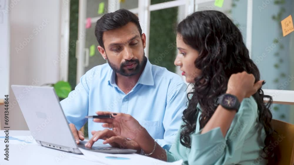Male and female Coworkers at office discussing from laptop during meeting - concept of expert guidance, startup collaboration and business planning Male and female Coworkers at office discussing from laptop during meeting - concept of expert guidance, startup collaboration and business planning