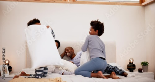 Family, pillow fight and playing in bedroom with happiness, communication and peace in the morning in home. Black people, parents or boy children with bonding, love and care on bed of house or energy photo