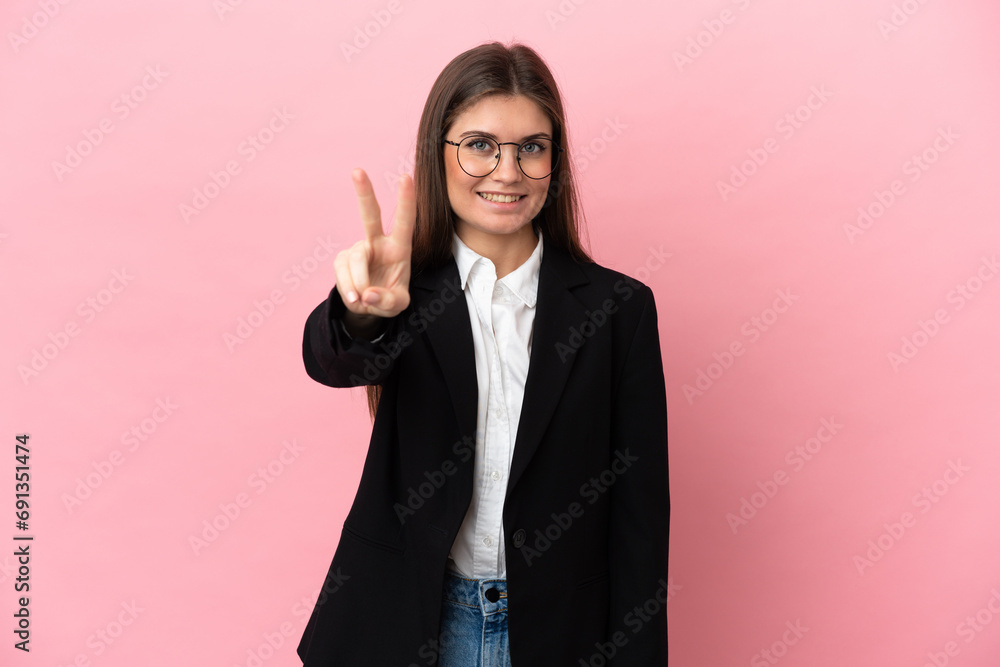Young Business caucasian woman isolated on pink background smiling and showing victory sign Young Business caucasian woman isolated on pink background smiling and showing victory sign