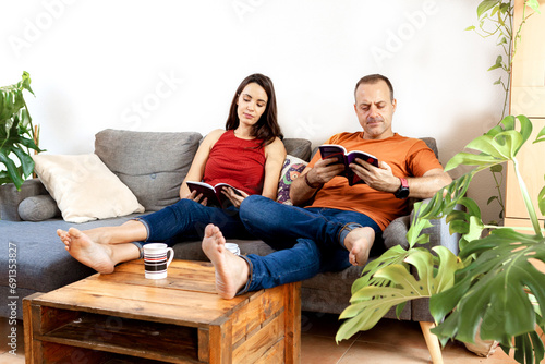 couple reading together quietly on the sofa at home